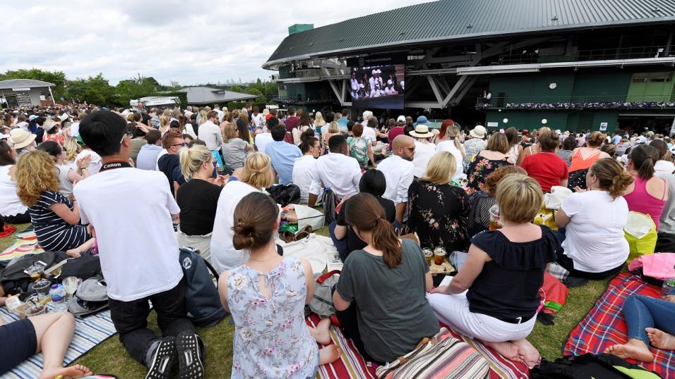 Tennis fans watch the action on the big screens at Wimbledon